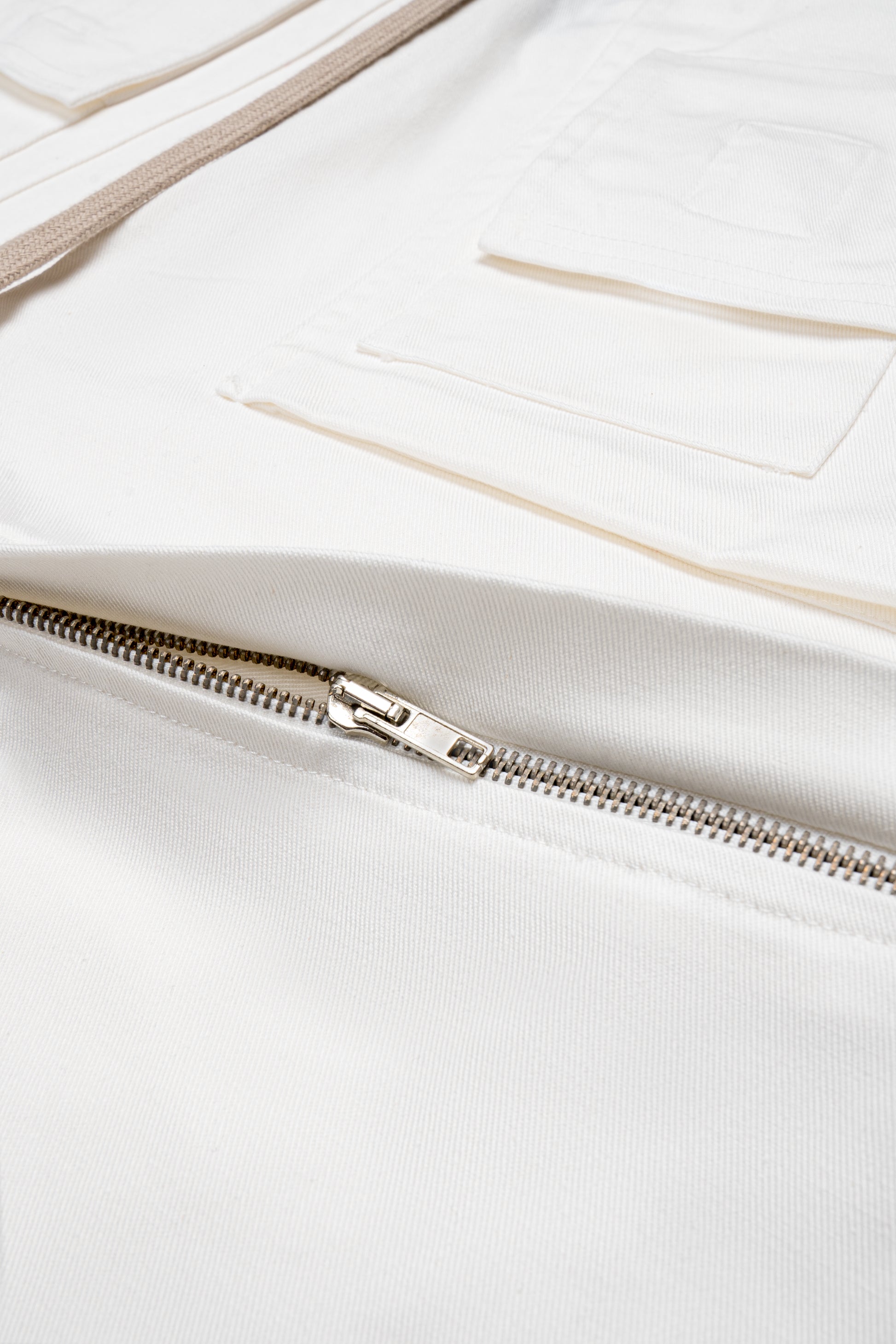 Zipper detailing close up from white convertible pants