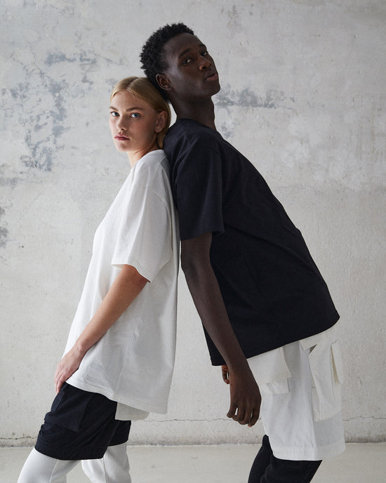 Models leaning against eachother wearing oversized t-shirt, leggings and convertible pants