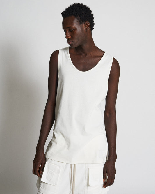 Front shot of male model wearing white tank top and convertible pants